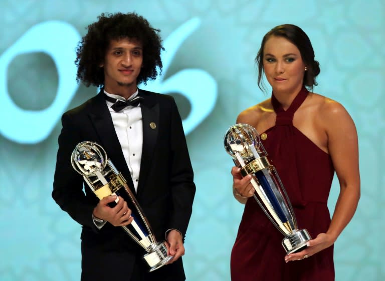 Emirate's Omar Abdulrahman (L), carrying the AFC Men's Footballer of the Year trophy, and Australia's Caitlin Foord, carrying the AFC Women's Footballer of the Year, during the Asian Football Confederation's Annual Awards ceremony on December 1, 2016