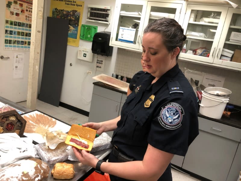 Jessica Anderson shows a pork sandwich confiscated from a traveler arriving from Shanghai at O'Hare International Airport