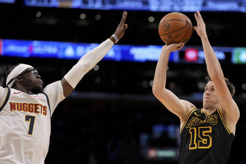 Los Angeles Lakers guard Austin Reaves (15) shoots over Denver Nuggets guard Reggie Jackson (7) during the first half of an NBA basketball game in Los Angeles, Thursday, Feb. 8, 2024. (AP Photo/Eric Thayer)