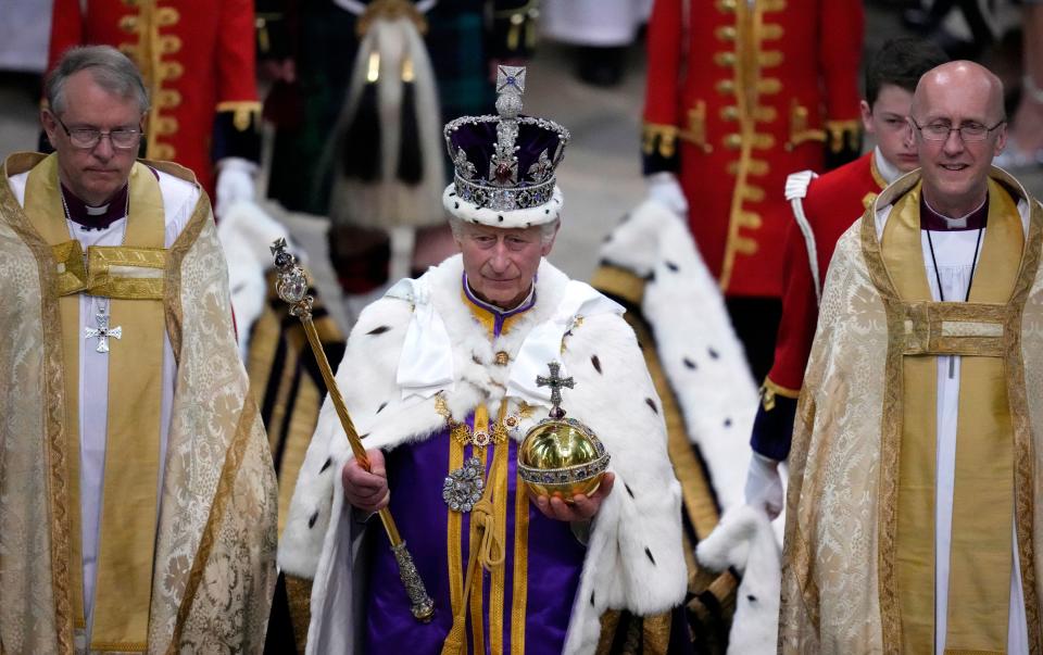 King Charles III, wearing the Imperial state Crown and carrying the Sovereign's Orb and Sceptre leaves after the Coronation Ceremony at Westminster Abbey on 6 May, 2023. (Getty Images)