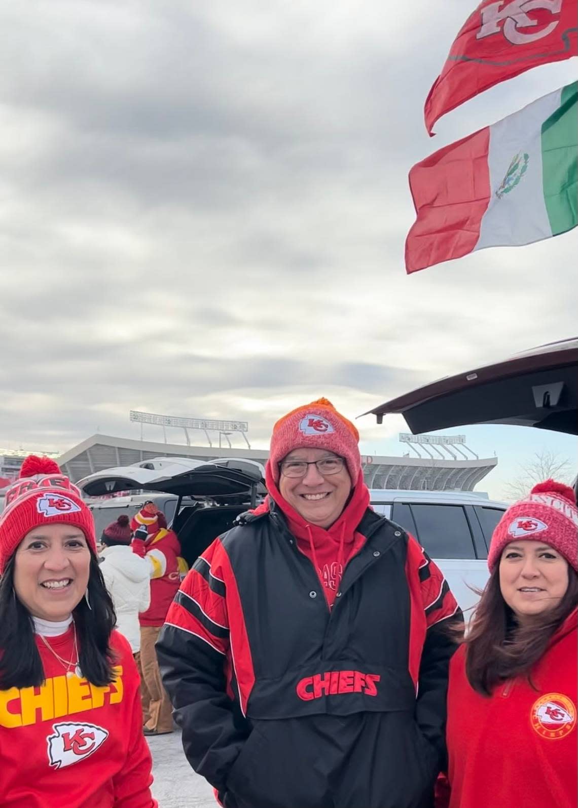 Siblings Rosanne Bailes of Lee’s Summit, Christian Garcia of Blue Springs and Francine Garcia of Independence set up a flag pole to display the banners of the Chiefs and of Mexico.