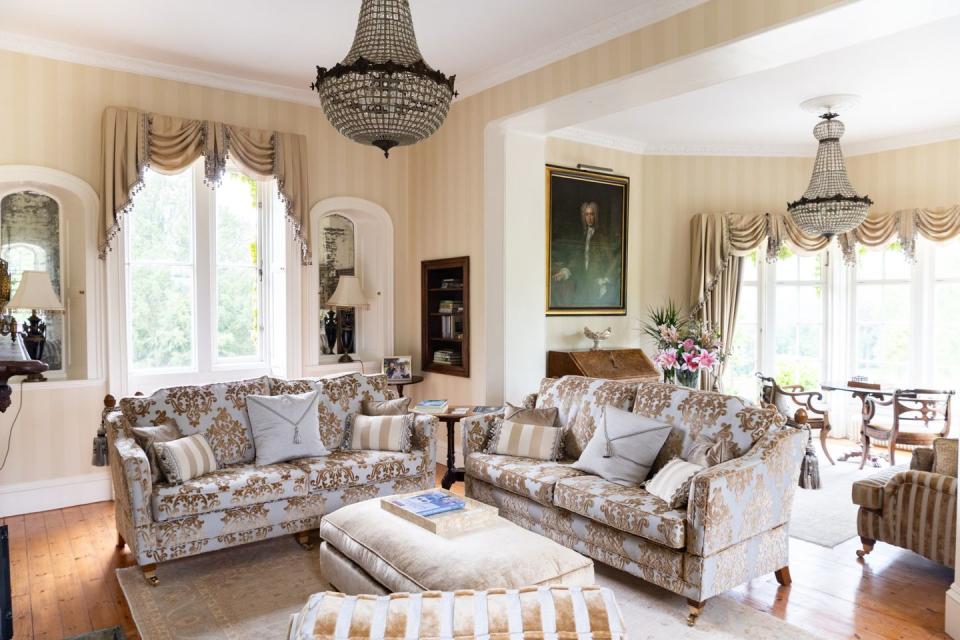 a living room with a large chandelier and a couch with large windows