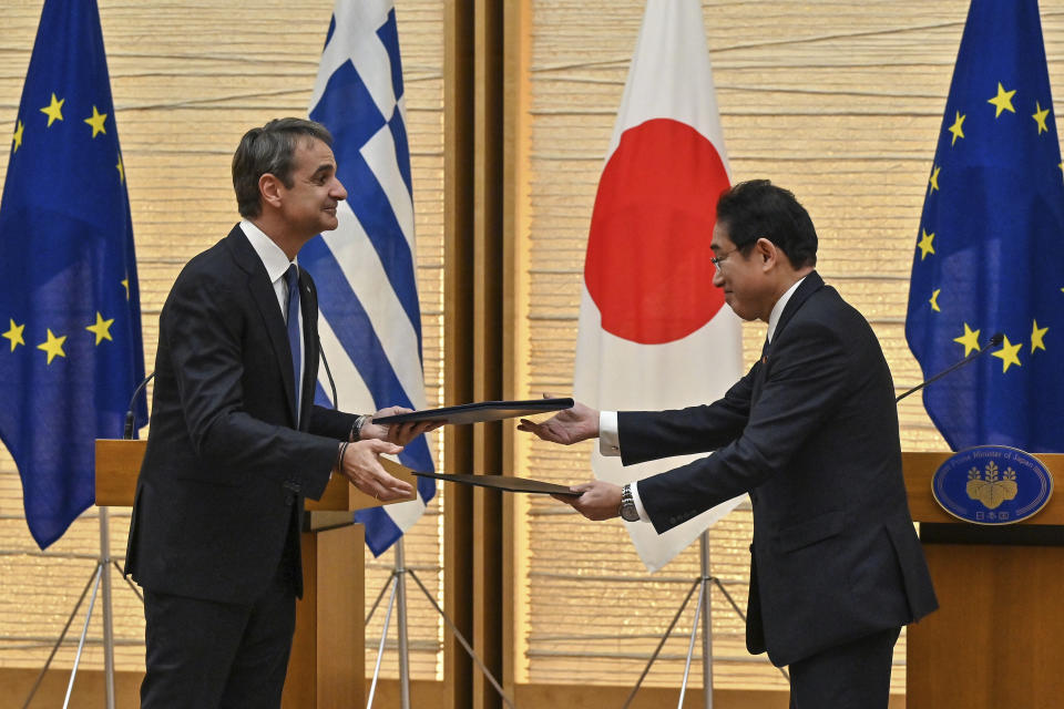 Greek Prime Minister Kyriakos Mitsotakis, left, exchanges documents with Japanese Prime Minister Fumio Kishida during their joint press conference following their meeting at the prime minister's official residence in Tokyo, Monday, Jan. 30, 2023. (Richard A. Brooks/Pool Photo via AP)