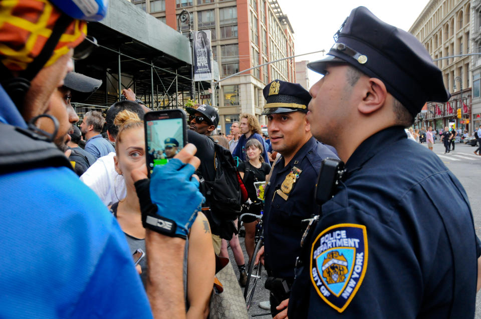 A cyclist captures video of a policeman during a ceremony