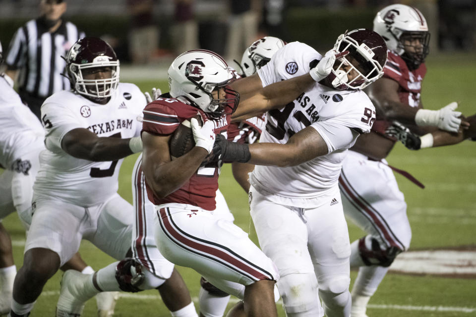 South Carolina running back Kevin Harris (20) stiff-arms Texas A&M defensive lineman Jayden Peevy (92) during the first half of an NCAA college football game Saturday, Nov. 7, 2020, in Columbia, S.C. (AP Photo/Sean Rayford)