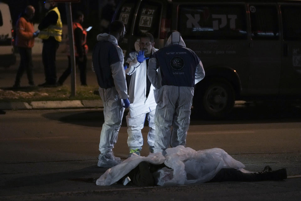 Israeli police inspect the scene of a shooting attack In Hadera, Israel, Sunday, March 27, 2022. A pair of gunmen killed two people and wounded four others in a shooting spree in central Israel before they were killed by police, according to police and medical officials. The identity of the gunmen was not immediately known, but police called them "terrorists," the term usually used for Arab assailants. (AP Photo/Ariel Schalit)