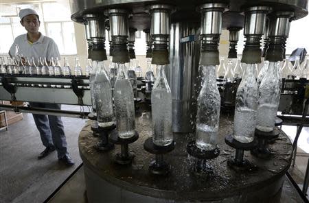 An employee works along an assembly line at a liquor factory in Taiyuan, Shanxi province in this August 10, 2012 file photo. REUTERS/Stringer/File