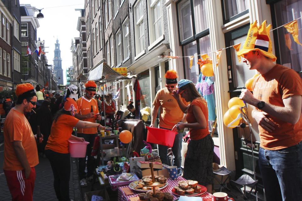 People celebrate King's Day in Amsterdam, Netherlands, Saturday, April 26, 2014. The Dutch celebrate the first ever King's Day, a national holiday held in honor of the newly installed monarch, King Willem Alexander. King's Day replaces the traditional Queen's Day. (AP Photo/Margriet Faber)