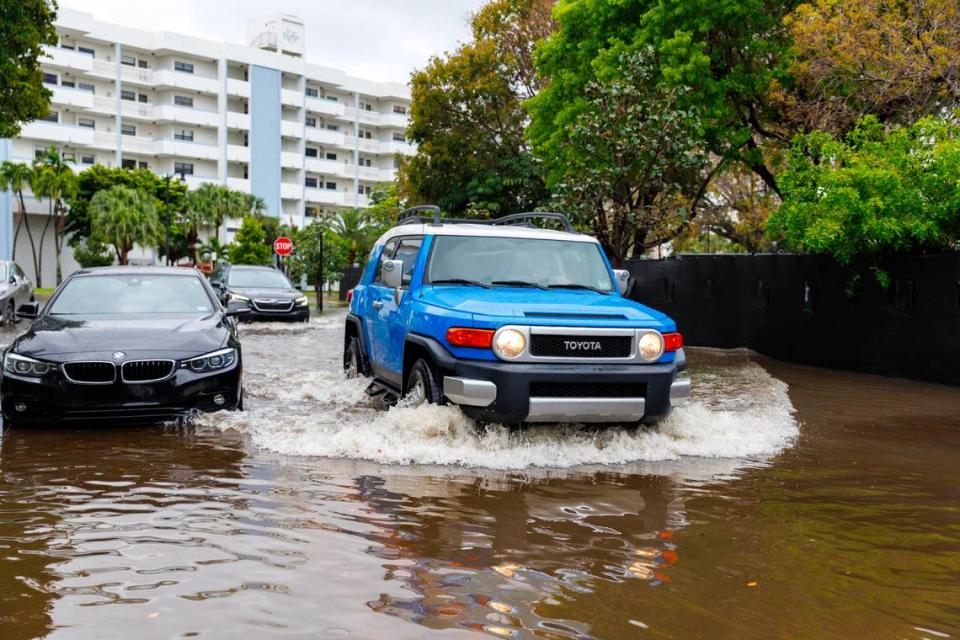 Cars go through the flooded road cause by heavy rains at North Bay Rd and 179th Dr. in Sunny Isles Beach on Wednesday, April 25, 2023.