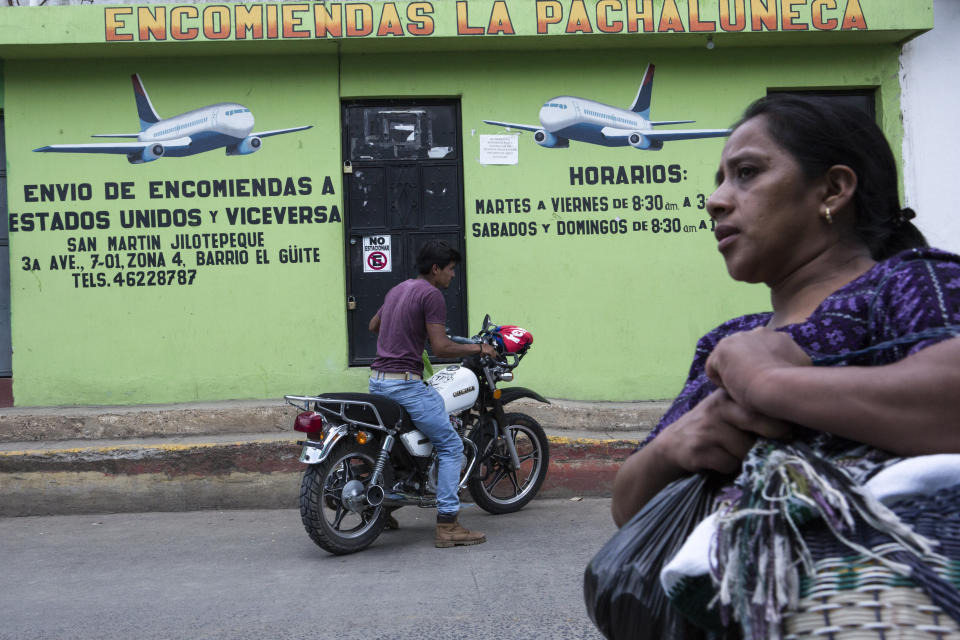 A man starts his motorbike next to a remittance business in San Martin Jilotepeque, Guatemala, Sunday, August 4, 2019. The sign on the wall reads in Spanish "Delivery of remittances to the United States and vice versa". San Martin Jilotepeque, like other towns in Guatemala, depends to a large extent on remittances, the money sent home by migrants living in the United States. (AP Photo/ Oliver de Ros)