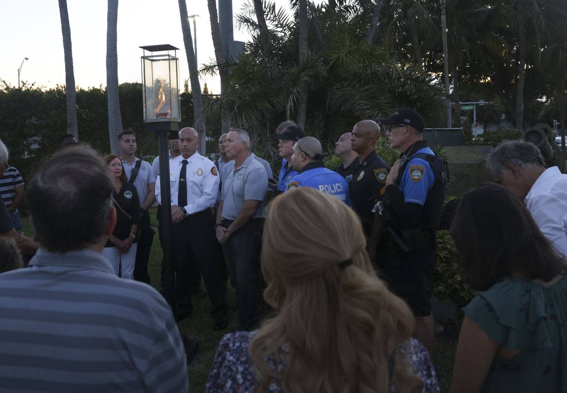 Miami Date Fire Rescue and community members gather on Wednesday, July 20, 2022, during a ceremony to extinguish the symbolic flame in front of the site where Champlain Towers South once stood in Surfside. One year ago, the last of 98 victims was recovered from the site.