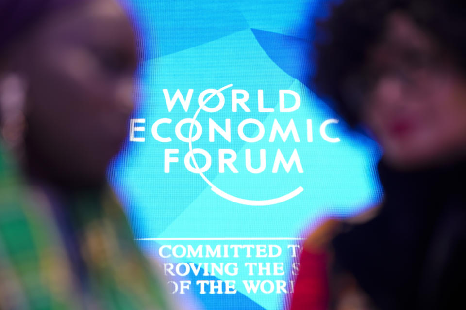 FILE - People talk in front of the logo of the World Economy Forum on the last day of the forum's Annual Meeting at the Congress Center in Davos, Switzerland, Friday, Jan. 19, 2024. On Friday, Jan. 19, The Associated Press reported on stories circulating online incorrectly claiming a deadly contagion known as Disease X is emerging and under discussion at the World Economic Forum’s 2024 annual meeting in Davos. (AP Photo/Markus Schreiber, File)