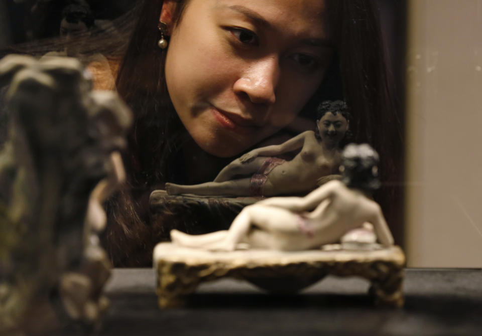 Una mujer observa una figura erótica en una exhibición de arte titulada “Jardines de placer: sexo en la antigua China”. (AP Photo/Kin Cheung)