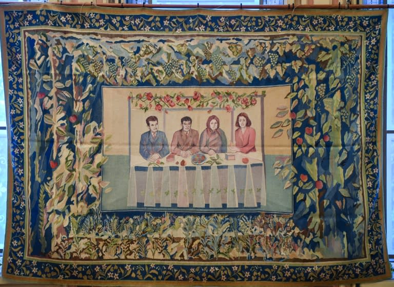 A tapestry showing late Romanian dictator Nicolae Ceausescu (L), his parents(C) and his wife Elena (R) is displayed at an auction house in Bucharest