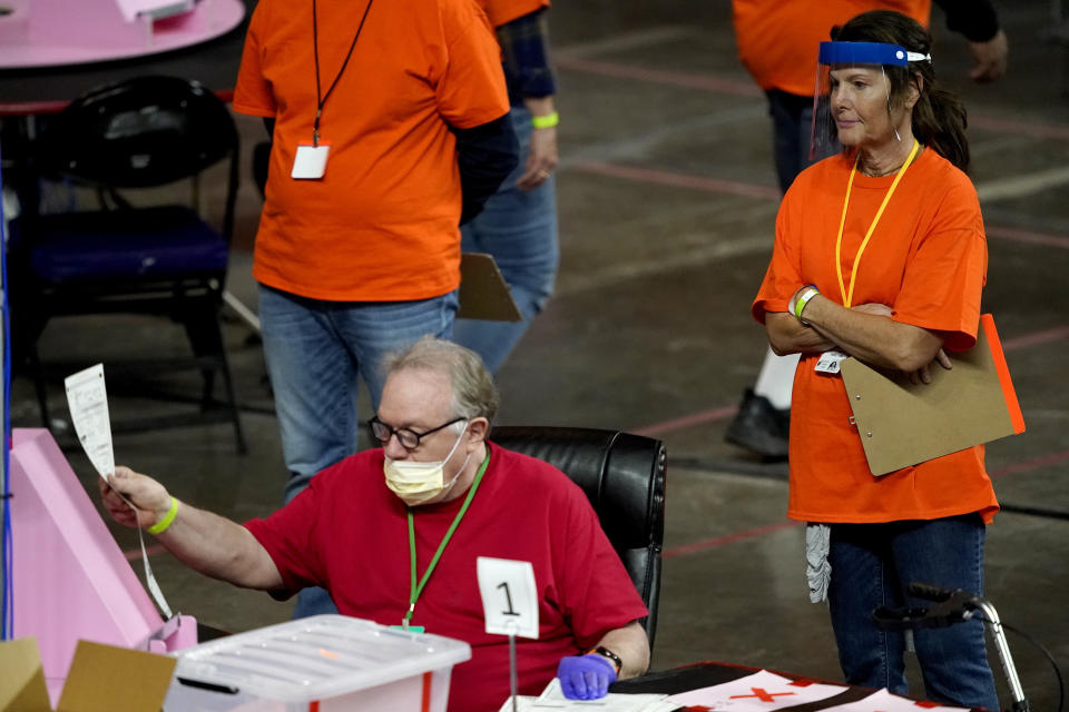 FILE - In this May 6, 2021 file photo, Maricopa County ballots cast in the 2020 general election are examined and recounted by contractors working for Florida-based company, Cyber Ninjas at Veterans Memorial Coliseum in Phoenix. A federal judge refused Friday, Aug. 26, 2022, to require that Arizona officials count ballots by hand in November, dismissing a lawsuit filed by the Republican nominees for governor and secretary of state based on false claims of problems with vote-counting machines. (AP Photo/Matt York, Pool)