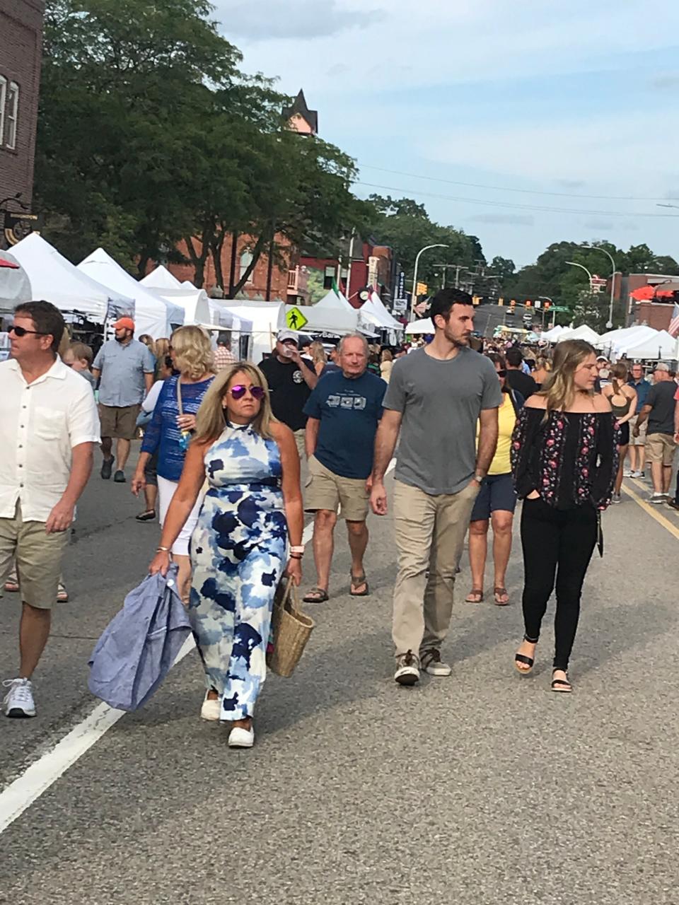 Shoppers stroll through downtown Brighton at the Main Street Wine, Art and Music Festival.