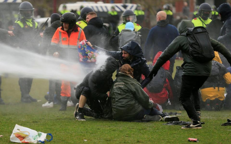 Police uses a water canon during a protest against restrictions in Amsterdam - Reuters