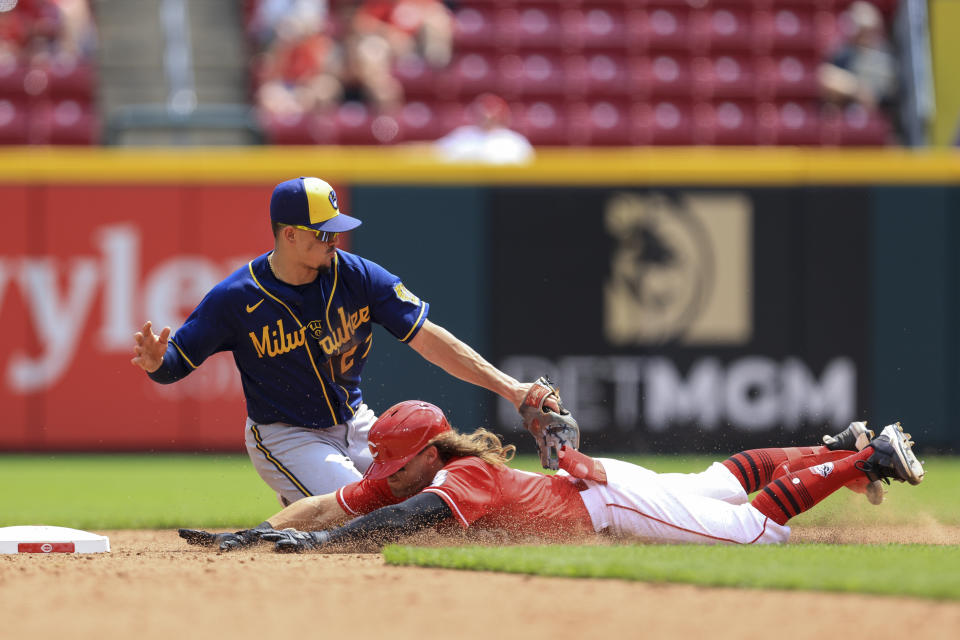 Cincinnati Reds' TJ Friedl, bottom, is tagged out at second base by Milwaukee Brewers' Willy Adames during the sixth inning of a baseball game in Cincinnati, Wednesday, May 11, 2022. (AP Photo/Aaron Doster)