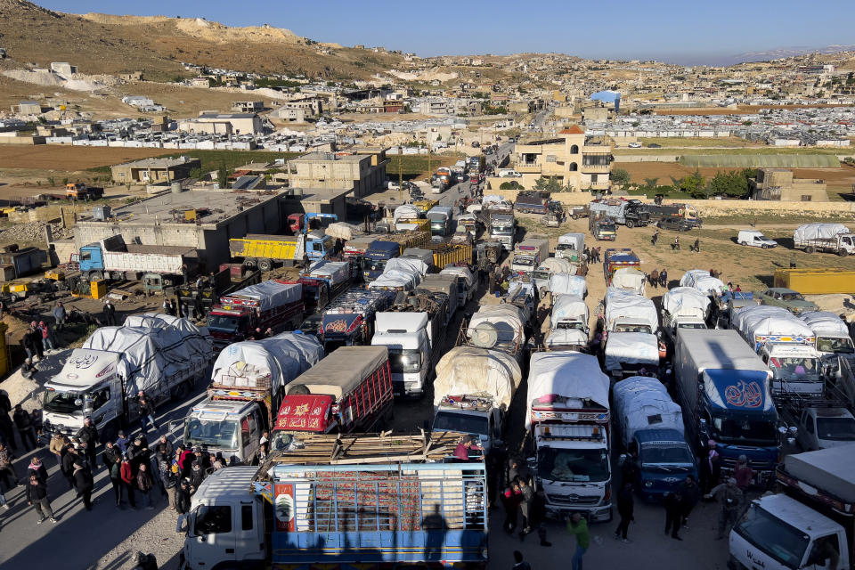 FILE - Syrian refugees gather near trucks with their belongings, as they prepare to go back home to Syria as a part of a voluntary return, in the eastern Lebanese border town of Arsal, Tuesday, May 14, 2024. For more than a decade, a steady flow of Syrians have crossed the border from their war-torn country into Lebanon. But anti-refugee sentiment is rising there, and over the past two months, hundreds of Syrian refugees have gone the other way. (AP Photo/Hussein Malla, File)