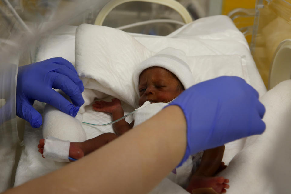 A nurse takes care of one of the nine babies protected in an incubator at the maternity unit of the Ain Borja clinic in Casablanca, Morocco, Thursday May 20, 2021, two weeks after Mali's Halima Cisse, 25, gave birth to nine healthy babies. (AP Photo / Abdeljalil Bounhar)