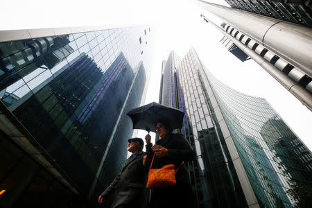 People walk through the financial district during rainy weather in London, Britain, September 23, 2018. Picture taken September 23, 2018. To match Exclusive BRITAIN-EU/CITY REUTERS/Henry Nicholls - RC1E2AF378E0