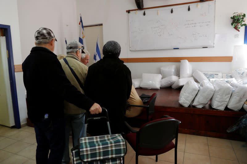 Holocaust survivors queue up to receive warm winter blankets which were donated to them by Chasdei Naomi, a non-profit organisation that provides help to thousands of Holocaust survivors in Israel, in Beit Shemesh, Israel