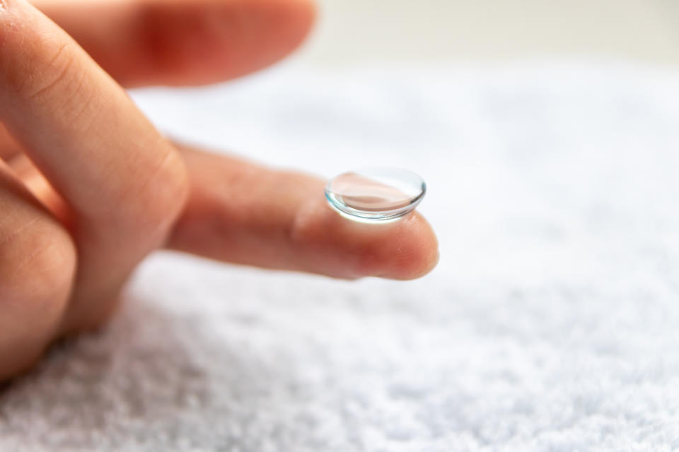 contact lens balanced on a fingertip