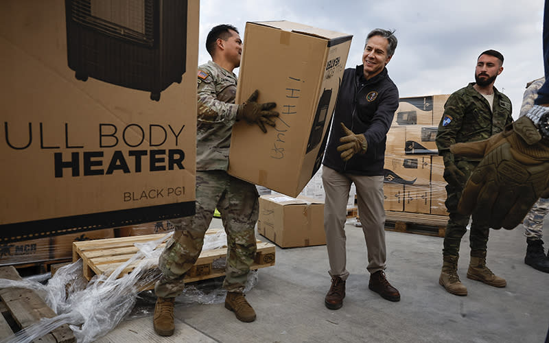 Secretary of State Antony Blinken helps U.S. military personnel load aid