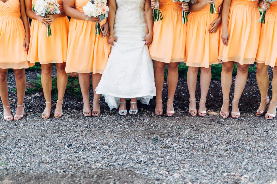 Low Section Of Bride With Bridesmaids Standing On Land