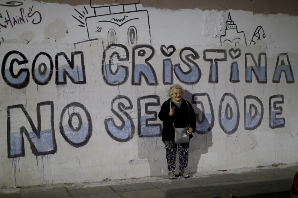 In this Oct. 6, 2018 photo, retiree Clara Schapiro, 75, poses for a picture backdropped by a wall emblazoned with a message that reads in Spanish: "With Cristina, you don't mess around," in reference to former President Cristina Fernandez, in Buenos Aires, Argentina. "She helps the people, helps everyone, so you're touched by a person like that," says Schapiro. (AP Photo/Natacha Pisarenko)