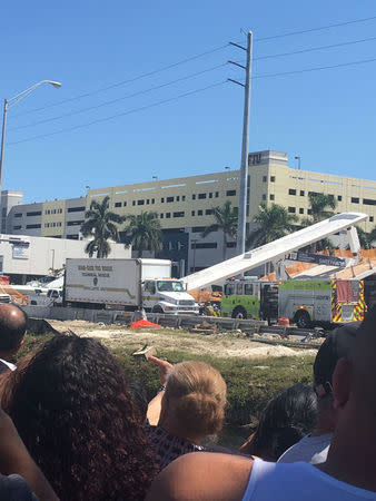 People gather at the scene of a collapsed pedestrian bridge at Florida International University in Miami, Florida, U.S., March 15, 2018 in this image obtain from social media. Instagram/ @barbituriinsua via REUTERS