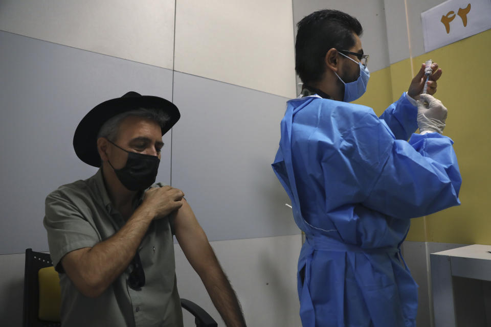 A health worker prepares a shot of Covid-19 vaccine for a citizen at a vaccination center in Iran Mall shopping center in Tehran, Iran, Monday, Aug. 9, 2021. Iran — like much of the world — remains far behind countries like the United States in vaccinating its public. So far only 3 million people out of Iran's population of 80 million have had both vaccine doses. (AP Photo/Vahid Salemi)