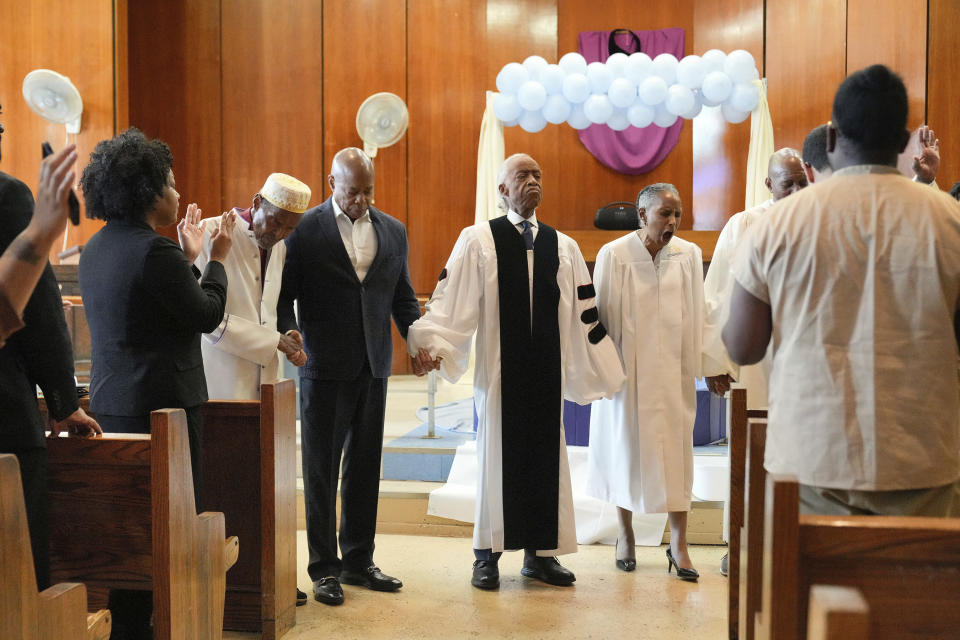 In this photo provided by the Office of the Mayor of New York, Mayor Eric Adams, center left, participates in a baptism ceremony with Rev. Al Sharpton, center, while visiting the Rikers Island jail complex in New York, Friday, March 29, 2024. (Ed Reed/Mayoral Photography Office via AP)