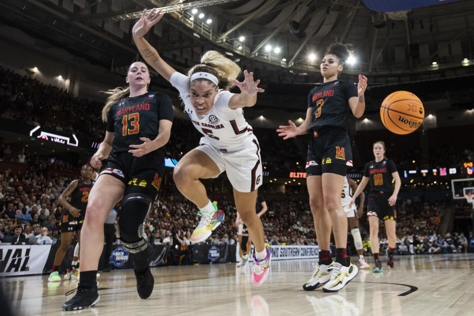 South Carolina's Victaria Saxton (5) goes for a loose ball against Maryland's Lavender Briggs (3) and Faith Masonius (13) in the first half of an Elite 8 college basketball game of the NCAA Tournament in Greenville, S.C., Monday, March 27, 2023. (AP Photo/Mic Smith)