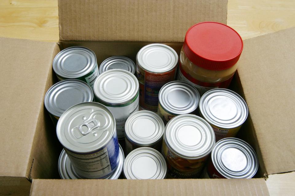 A cardboard box full of canned goods.