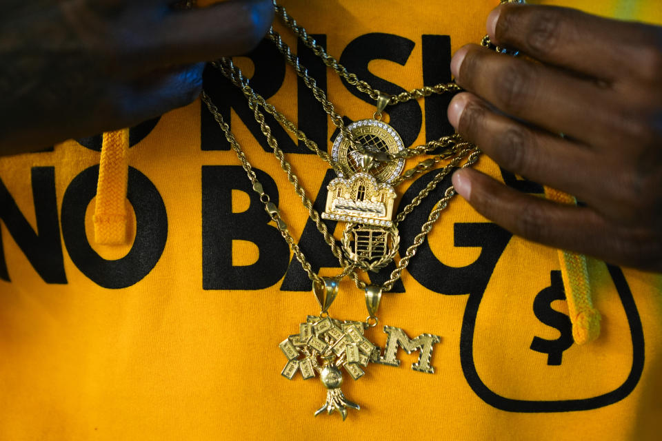 Cloud 9 Cannabis CEO and co-owner Sam Ward Jr. adjusts his chains, Thursday, Feb. 1, 2024, in Arlington, Wash. Cloud 9 is one of the first dispensaries to open under the Washington Liquor and Cannabis Board's social equity program, established in efforts to remedy some of the disproportionate effects marijuana prohibition had on communities of color. (AP Photo/Lindsey Wasson)