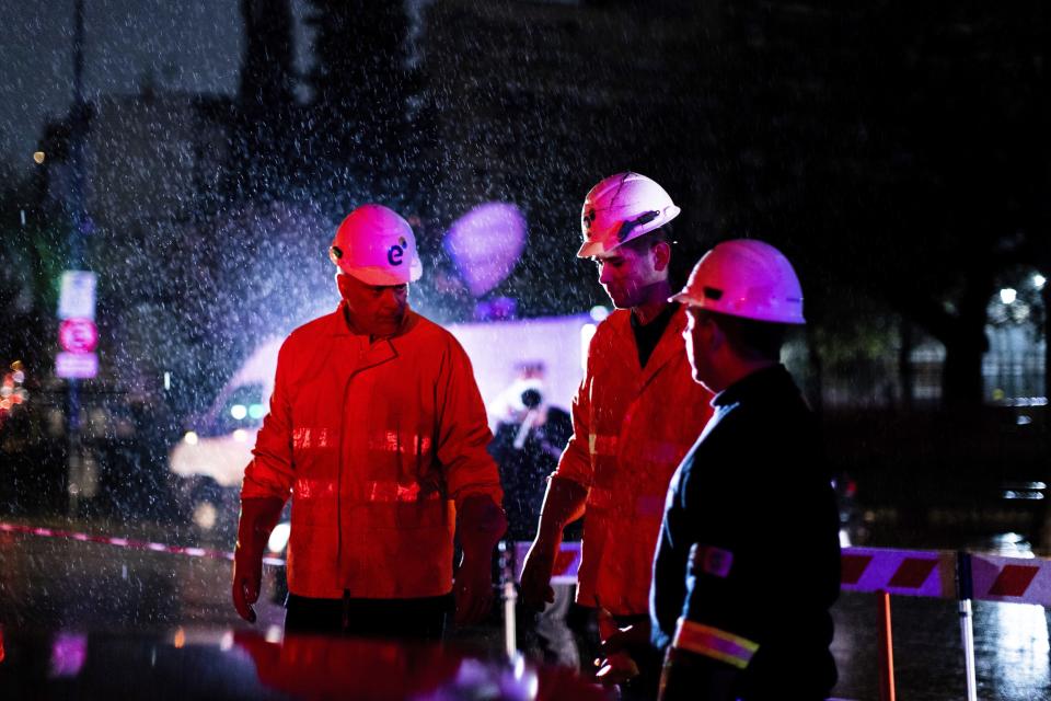 Technicians of Edenor electricity company stand under the rain as they work to fix a generator during a blackout in Buenos Aires, Argentina, Sunday, June 16, 2019. A massive blackout left tens of millions of people without electricity in Argentina, Uruguay and Paraguay on Sunday in what the Argentine president called an “unprecedented” failure in the countries’ power grid. (AP Photo/Tomas F. Cuesta)