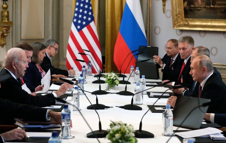 US President Joe Biden and Russian President Vladimir Putin face each other across the table during their meeting in Geneva, June 16 2021.