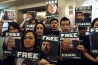 Greenpeace activists in Hong Kong carry portraits of their detained colleagues as they protest outside the Russian Consulate in Hong Kong September 27, 2013. A Russian court ordered 20 Greenpeace activists from around the world to be held in custody for two months pending further investigation over a protest against offshore oil drilling in the Arctic, drawing condemnation and a vow to appeal. (REUTERS/Bobby Yip)