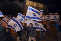 Israeli right-wing demonstrators gather following a stabbing attack earlier in the day in the Sheikh Jarrah neighborhood in east Jerusalem, Wednesday, Dec. 8, 2021. An Israeli woman was stabbed and lightly wounded in the attack. The suspect, a Palestinian female minor, fled the scene and was later arrested inside a nearby school, police said. (AP Photo/Mahmoud Illean)