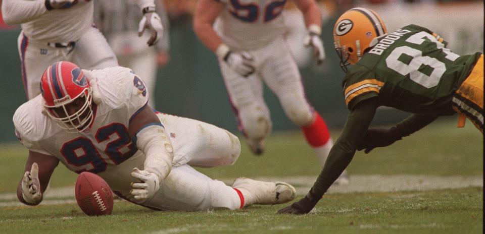 Buffalo nose tackle Ted Washington beats Green Bay receiver Robert Brooks for a fumble recovery.