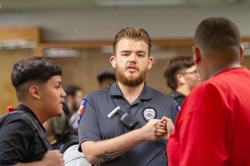 A Montwood High School security guard fist bumps a student during passing time between classes on Aug. 8, 2023. "We’re not out to get them," one officer said of students.