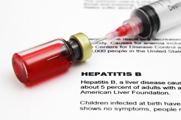 Syringe and vial on top of hepatitis B document