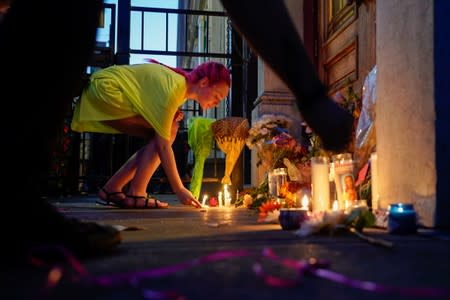 A mourner leaves a candle at the scene of a mass shooting in Dayton