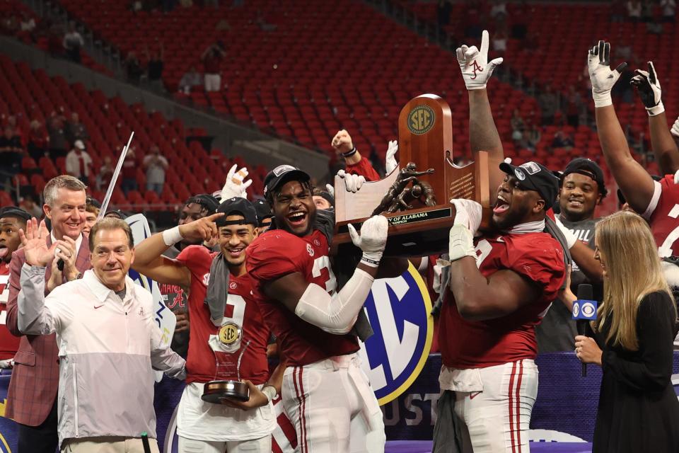 Alabama head coach Nick Saban, quarterback Bryce Young (9), linebacker Will Anderson Jr. (31), and defensive lineman Phidarian Mathis (48) celebrate with the SEC championship trophy after the Crimson Tide defeated Georgia.