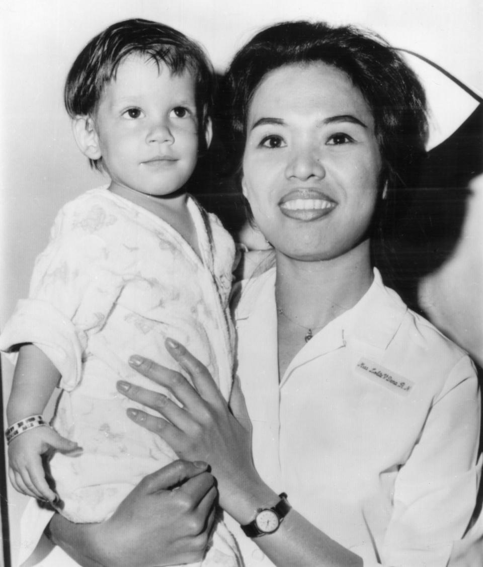 FILE - In this June 17, 1966 file photo, a boy, dubbed "Scott McKinley" by the State Child Service is held by Nurse Lolita V. Tana in Newark, N.J. McKinley has been adopted by Chester and Dora Fronczak, a Chicago couple who believe him to be their son kidnapped in 1964. (AP Photo, File)