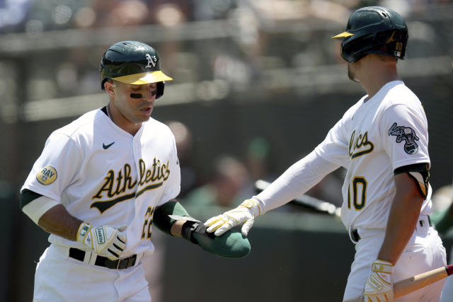 Oakland Athletics' Ramon Laureano (22) is congratulated by Chad Pinder (10) after scoring in the first inning of a baseball game against the Minnesota Twins in Oakland, Calif., on Wednesday, May 18, 2022. (AP Photo/Scot Tucker)