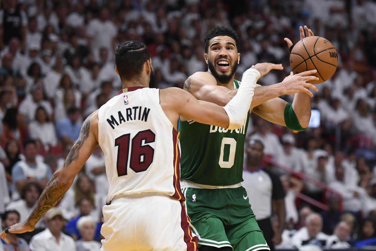Miami Heat forward Caleb Martin bats the ball away from Boston Celtics forward Jayson Tatum during Game 6 of the Eastern Conference finals on May 27, 2023, in Miami. Game 7 is Monday night in Boston. (AP Photo/Michael Laughlin)