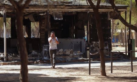 A man cries at the entrance to a burnt camping following a forest fire near Donana National Park, in Matalascanas, southern Spain June 26, 2017. REUTERS/Jon Nazca