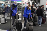 Travelers walk through Terminal 3 at the O'Hare International Airport in Chicago, Thursday, Dec. 21, 2023. It's beginning to look a lot like a hectic holiday travel season, but it might go relatively smoothly if the weather cooperates. (AP Photo/Nam Y. Huh)